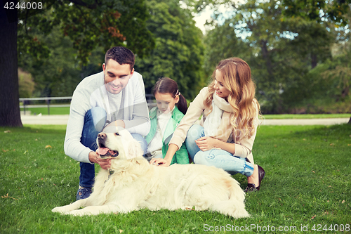 Image of happy family with labrador retriever dog in park