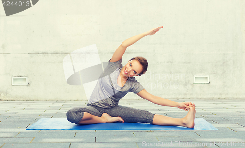 Image of happy woman making yoga and stretching on mat