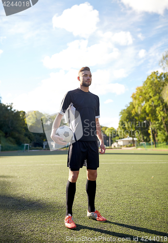 Image of soccer player with ball on football field