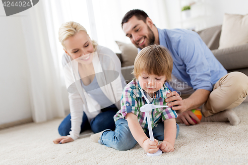 Image of happy family playing with toy wind turbine