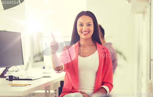Image of happy african woman showing thumbs up at office