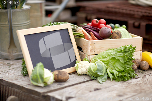 Image of close up of vegetables with chalkboard on farm