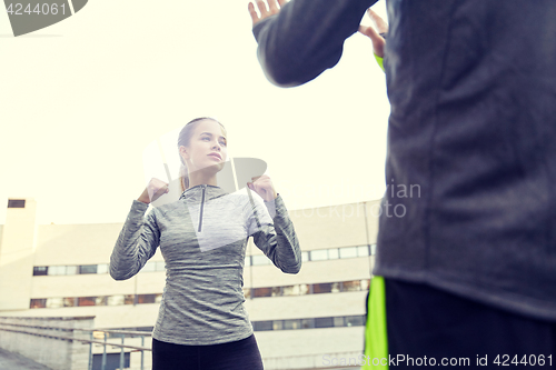 Image of woman with trainer working out self defense strike