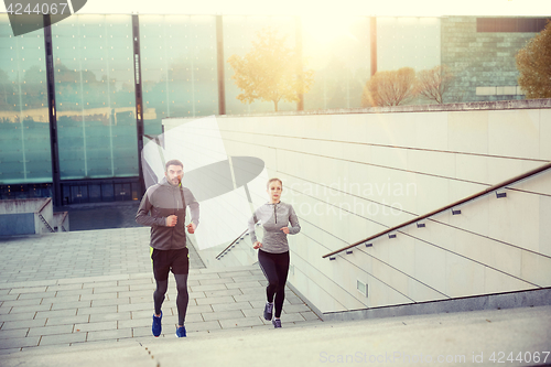 Image of happy couple running upstairs on city stairs