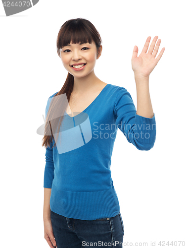 Image of happy smiling young woman waving hand over white