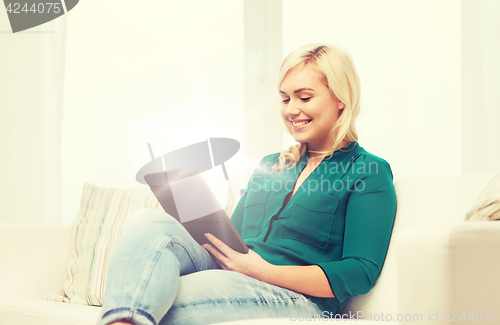 Image of smiling woman with tablet pc at home