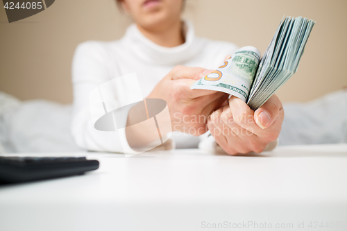 Image of business, finance, saving, banking and people concept - close up of woman hands counting us dollar money