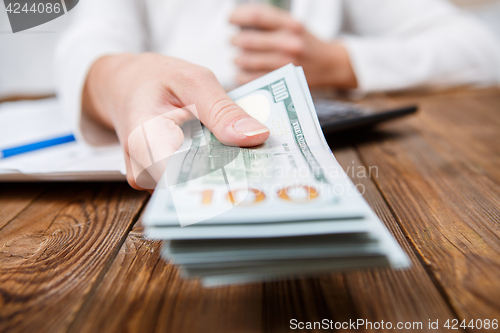 Image of Hands of person proposing money to you - closeup shot