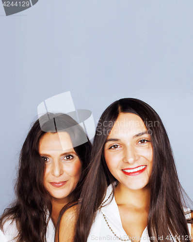 Image of cute pretty teen daughter with mature mother hugging, fashion st