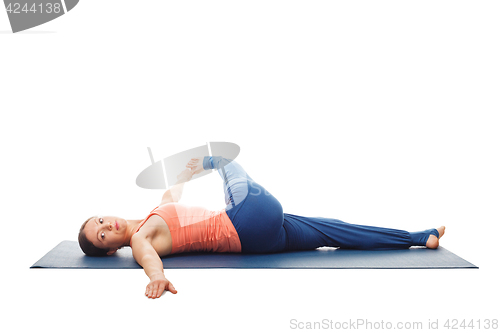 Image of Woman doing Yoga asana Revolved knee-to-chest Pose isolated