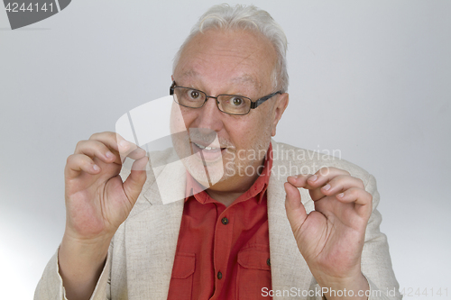 Image of White-haired man shows OK sign with fingers