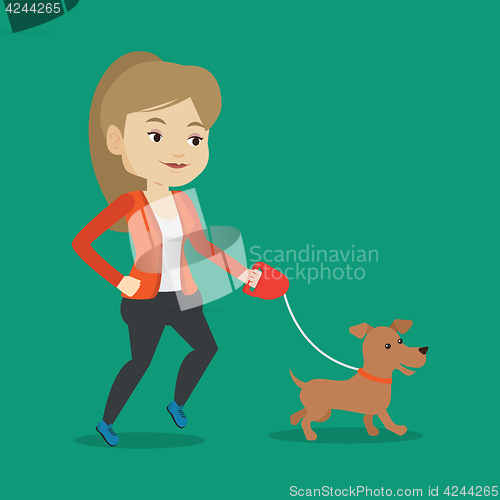 Image of Young woman walking with her dog.