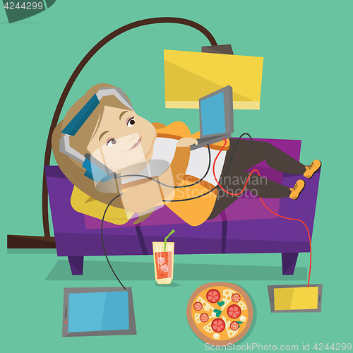 Image of Woman lying on sofa with many gadgets.