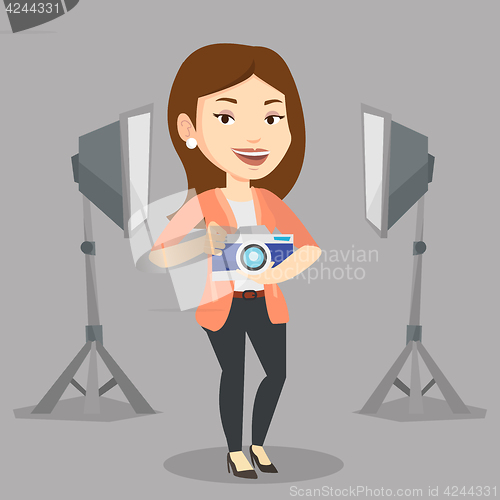 Image of Photographer with camera in photo studio.