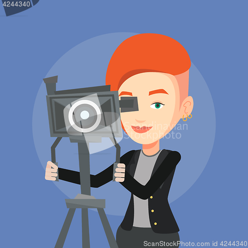 Image of Cameraman with movie camera on tripod.