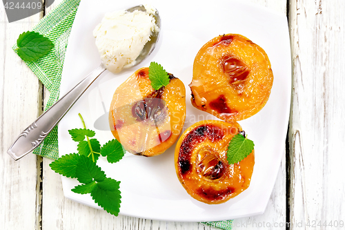 Image of Quince baked with ice-cream and mint in plate on board top