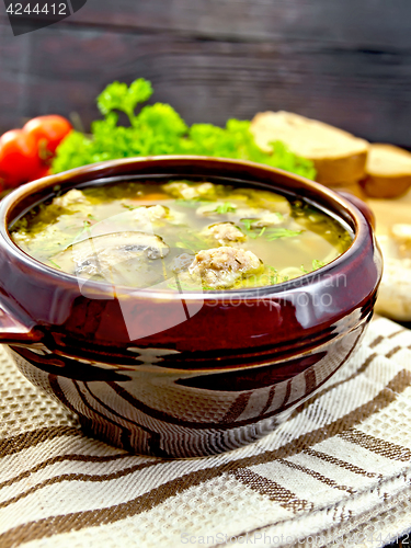 Image of Soup with meatballs and mushrooms in pottery on dark board