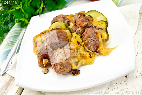 Image of Meatballs with zucchini and cheese in plate on board