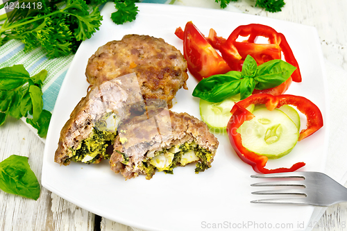 Image of Cutlets stuffed with basil in plate on board