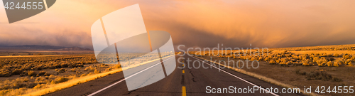 Image of Storm Brews over Two Lane Highway At Sunset