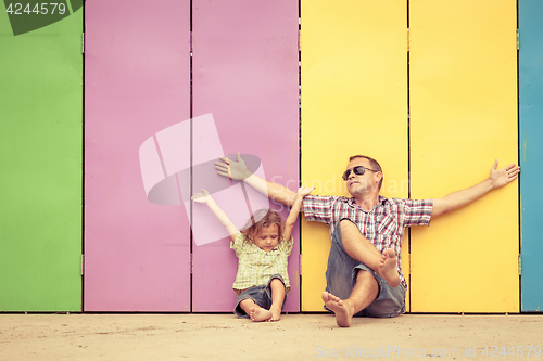 Image of Father and son playing near the house at the day time.