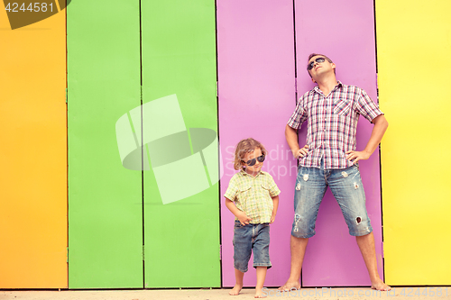 Image of Father and son relaxing near the house at the day time.