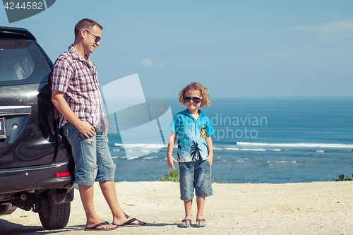 Image of Father and son playing on the beach at the day time.