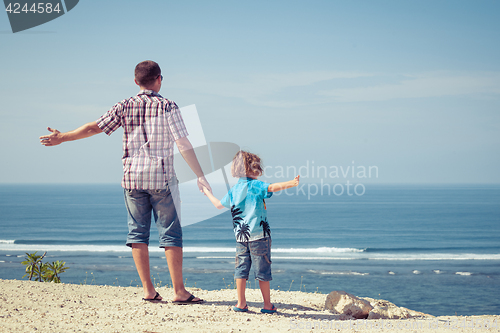 Image of Father and son playing on the beach at the day time.