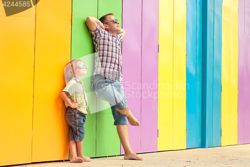 Image of Father and son relaxing near the house at the day time.