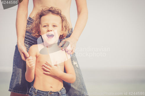 Image of Mother and son playing on the beach at the day time.