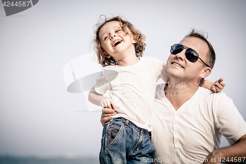 Image of Father and son playing on the beach at the day time.