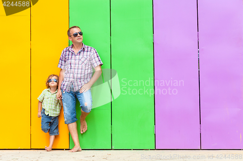 Image of Father and son relaxing near the house at the day time.