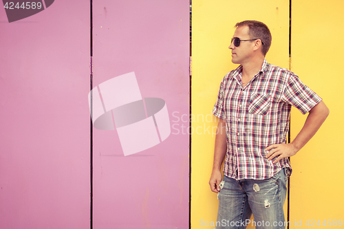 Image of  man looking away standing near the wall.