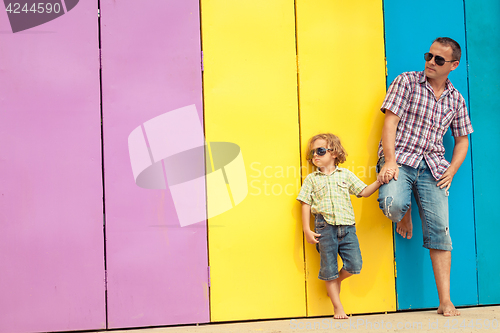 Image of Father and son relaxing near the house at the day time.