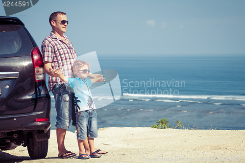 Image of Father and son playing on the beach at the day time.