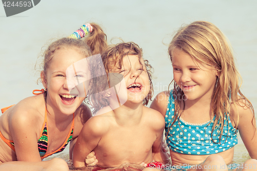 Image of Three happy children  playing on the beach