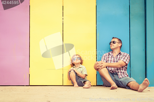 Image of Father and son playing near the house at the day time.
