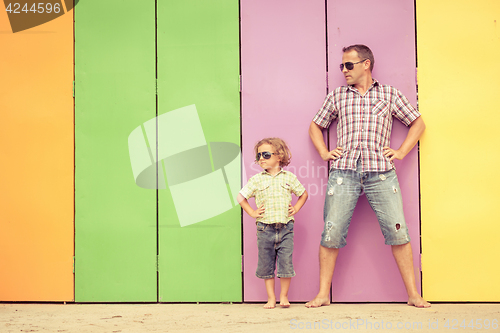 Image of Father and son playing near the house at the day time.