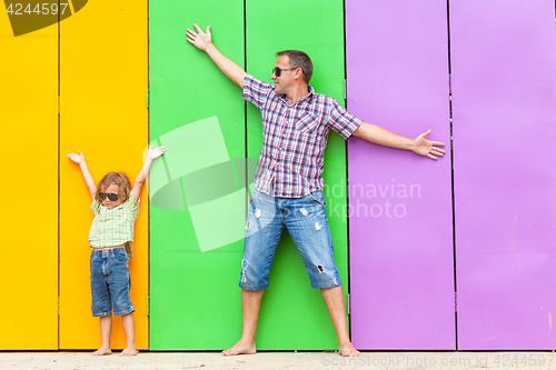 Image of Father and son relaxing near the house at the day time.