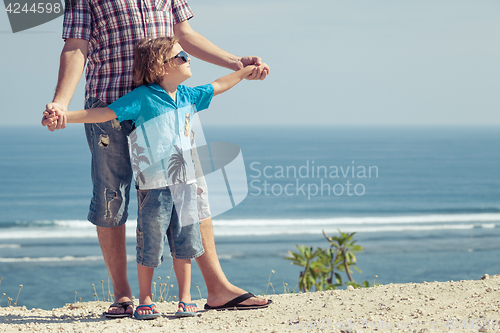 Image of Father and son playing on the beach at the day time.