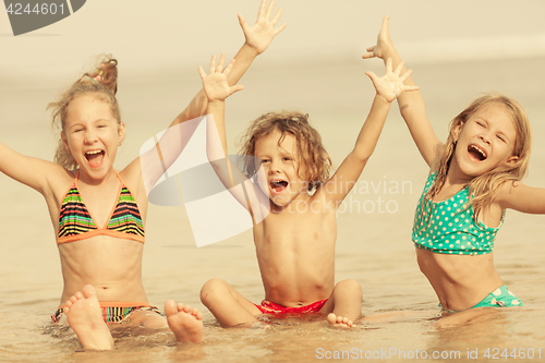 Image of Three happy children  playing on the beach