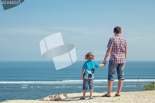 Image of Father and son playing on the beach at the day time.