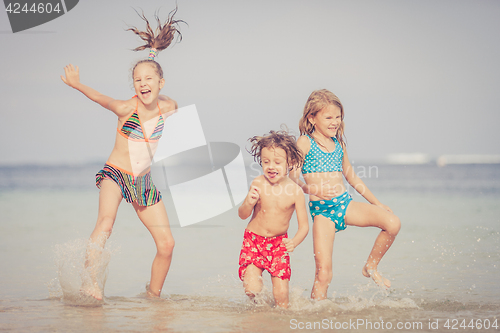 Image of Three happy children  playing on the beach