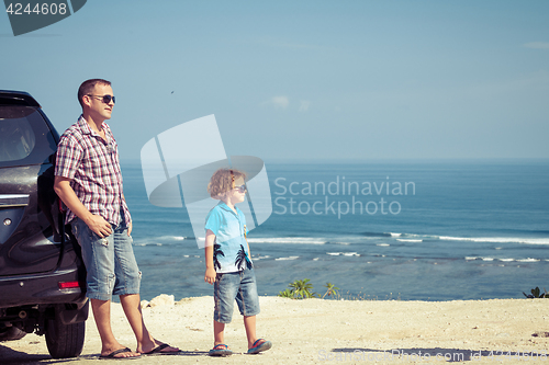 Image of Father and son playing on the beach at the day time.