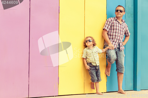 Image of Father and son playing near the house at the day time.