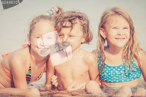 Image of Three happy children  playing on the beach