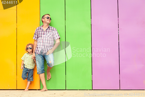 Image of Father and son relaxing near the house at the day time.