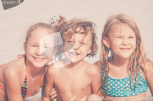 Image of Three happy children  playing on the beach