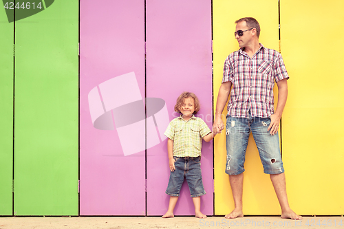 Image of Father and son relaxing near the house at the day time.