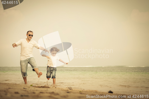 Image of Father and son playing on the beach at the day time.